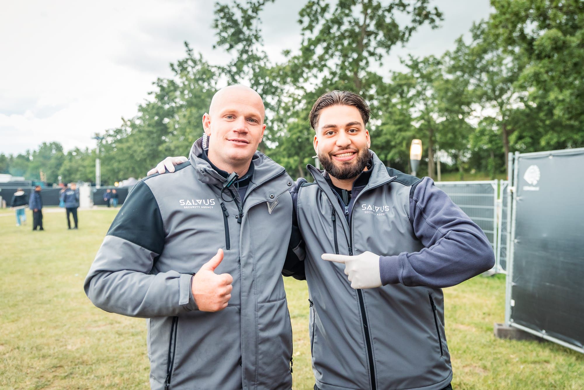 Twee lachende Salvus-beveiligers op het festivalterrein